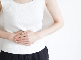 お腹を押さえる女性